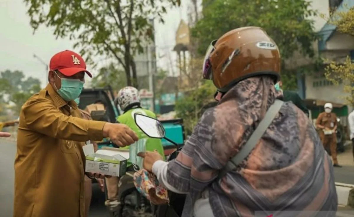 Bupati Hulu Sungai Tengah Samsul Rizal membagikan masker kepada pengendara di Barabai