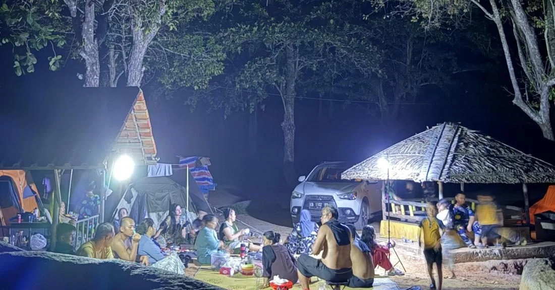 Wisatawan di Pantai Pasir Panjang Singkawang menggunakan lampu darurat saat terjadi pemadaman listrik bergilir.