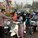 Anggota Polsek Banjarmasin Utara membagikan masker gratis kepada pengendara motor di tengah kabut asap