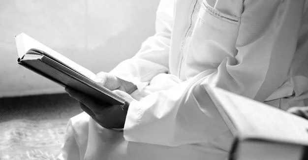 Seorang pria sedang membaca buku Yasin dan Tahlil dengan khusyuk