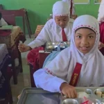 Siswa SDN Semangat Dalam 5 sedang menerima paket makanan bergizi dalam program pemerintah.