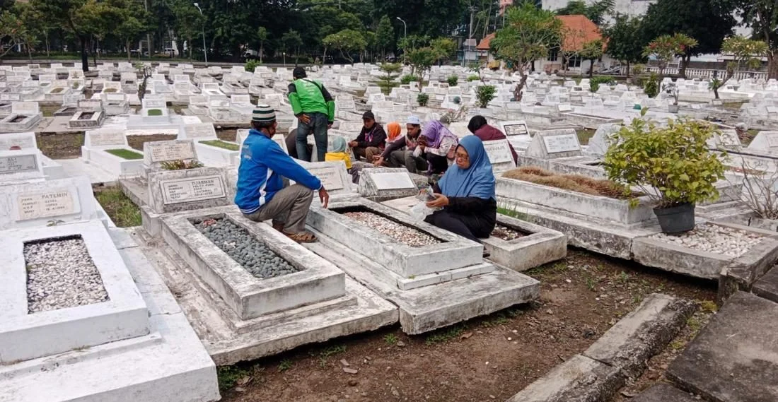 Seseorang sedang berdoa di area pemakaman pahlawan dengan khusyuk
