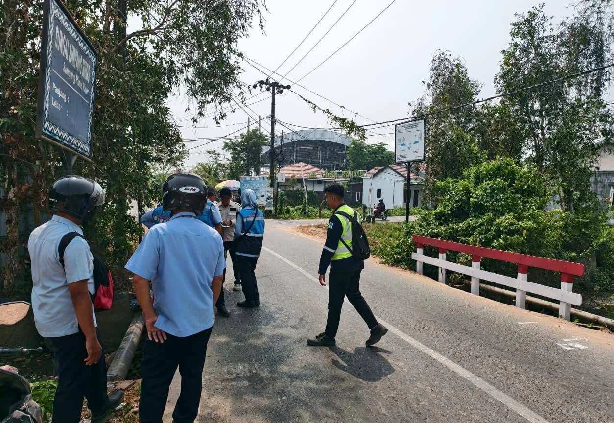 Pekerja sedang meninjau rencana perbaikan jembatan desa di Kalimantan Selatan