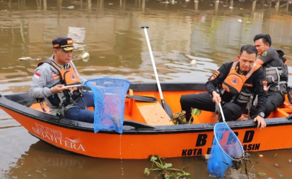 Personel Polresta Banjarmasin dan warga sedang bergotong royong membersihkan Sungai Pemurus dari sampah.