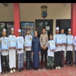 Petugas kepolisian memberikan santunan kepada anak yatim piatu