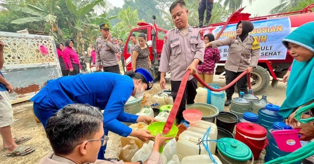 Polisi menyalurkan bantuan air bersih dari mobil tangki kepada warga Desa Danau Ganting