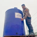 Proses gotong royong warga dan polisi saat memasang tandon air di Desa Bulayak