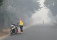 Petugas kebersihan menyapu jalanan di tengah kepungan kabut asap karhutla pekat di Kotawaringin Barat