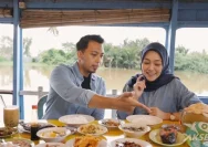Wisatawan menikmati kuliner khas Banjar di atas jukung di pinggir Sungai Martapura Banjarmasin.